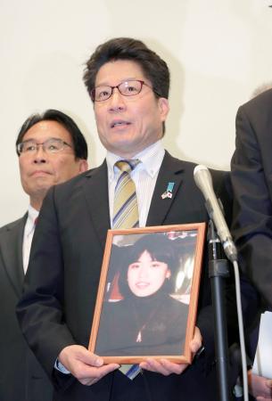 　米ワシントンへの出発前、有本恵子さんの写真を手にして記者会見する被害者家族会代表の横田拓也さん＝２９日午前、羽田空港