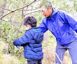 生い茂ったつるを切る親子＝８日、鳥取市福部町湯山の海潮音の森