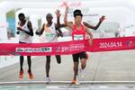 　北京で行われたハーフマラソンの大会で、１位でゴールする中国の何傑選手（手前）＝１４日（ＣＮＳ＝共同）