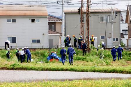 　長野県須坂市の事故現場付近を調査する鉄道事故調査官ら＝２２日午後