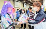 啓発グッズを受け取る道の駅の利用者（右）＝新温泉町栃谷の道の駅山陰海岸ジオパーク浜坂の郷