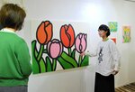 来場者に作品について説明するミヤザキさん（右）