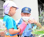 署員と一緒に短冊を取り付ける園児＝１１日、新温泉町戸田の美方署