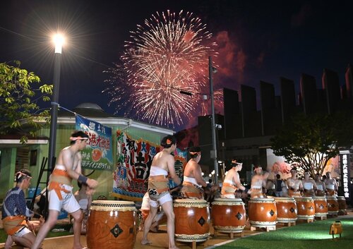 花火をバックに力強い演奏を披露する境港大漁太鼓＝２１日、鳥取県境港市大正町のゲゲゲの広場