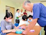 坂本さん（右）の助言を受けながら器作りに挑戦する児童＝２日、鳥取市気高町浜村の町農業者トレーニングセンター