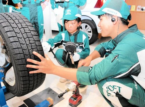 整備士（右）の指導で、タイヤの空気圧を点検する参加児童