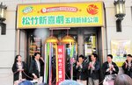 くす玉を割って１００周年を祝う松竹新喜劇のメンバー＝１７日、大阪市中央区の大阪松竹座前