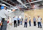 スタッフの説明を受けながら建設現場を見て回る参加者ら