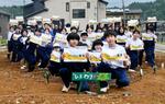 　石川県穴水町の解体されたビル跡地で行われたヒマワリの種まきに参加した中学生ら＝２０日午後