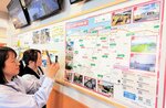 ガイドマップに掲載されているＱＲコードから観光地の情報を読み取る利用者ら＝１４日、北栄町国坂の道の駅「ほうじょう」