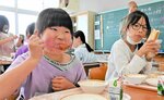 釧路市の名物「ザンタレ」を頬張る児童＝７日、鳥取市賀露町の賀露小