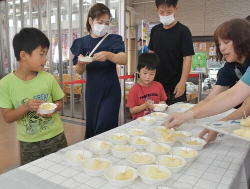 食べ比べ用の梨を手にする来場者＝３１日、鳥取市賀露町西３丁目の地場産プラザわったいな