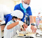 イカの内臓を丁寧に取り除く児童＝２７日、香美町香住区訓谷の佐津小