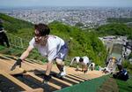 　スキーのジャンプ台を着地ゾーンから頂上に向かって駆け上がる人たち＝１８日午前、札幌市の大倉山ジャンプ競技場
