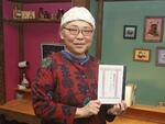 　宮本真人さんの著書を手にする北見伸子さん＝４月、北海道函館市