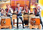 米子がいな太鼓の５０周年記念公演で演奏する本田さん（前列左から２人目）＝１７日、ＪＲ米子駅前