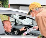 ドライバーに啓発チラシを手渡し交通安全を呼びかける参加者＝５日、香美町香住区下岡の国道１７８号