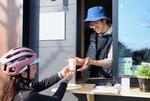 　客にコーヒーを手渡す深沢諒さん＝２月、福島県双葉町