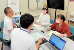 県男女青少年課家庭応援班の担当者に取材する学生２人（右）