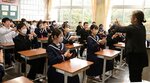 手話普及支援員（右）から手話を教わる生徒たち＝１３日、鳥取市浜坂東１丁目の中ノ郷中