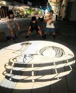 歩道に浮かび上がった夏季限定の妖怪影絵＝１７日夜、境港市松ケ枝町