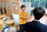 　「にしまるーむ」で生徒と会話するスタッフの本間優輔さん＝９月、東京都豊島区立西池袋中