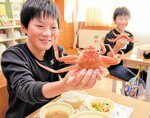 給食にお目見えしたセコガニに笑顔を見せる児童＝１４日、新温泉町高末の浜坂東小