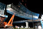 大型クレーンで慎重につり上げられる鋼鉄製の橋桁＝８日午後９時２０分、鳥取県北栄町弓原の北条ジャンクション