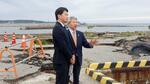 　石川県珠洲市の飯田港で、泉谷満寿裕市長（右）から説明を受ける兵庫県の斎藤元彦知事＝２２日午後