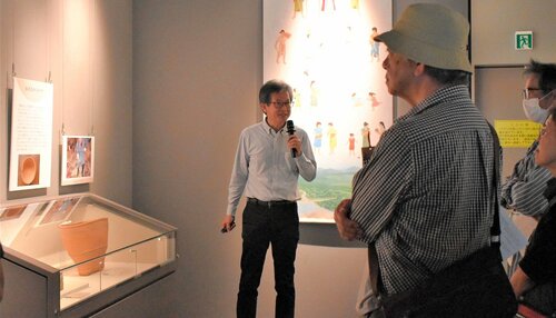 弥生時代の人々が使っていたかごについて説明する浜田課長補佐（中央）＝５日、鳥取市青谷町吉川の青谷かみじち史跡公園