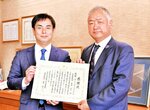 感謝状を手にする高橋社長（左）と森本県関西本部長＝米子市新開２丁目のサテライトコミュニケーションズネットワーク