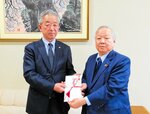 目録を手渡す寺谷会長（左）