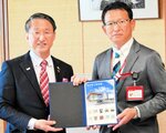 砂支社長からフレーム切手を受け取る平井知事（左）＝２６日、鳥取県庁