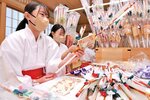 破魔矢に絵馬や鈴を飾りつけるみこ＝２７日、鳥取市国府町宮下の宇倍神社