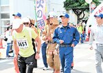 業務服姿で火災予防を呼びかけながら走る美方広域消防本部の職員たち＝２６日、新温泉町役場前