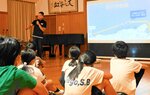 児童たちに香住沖海戦について説明する小林副理事長＝９日、香美町香住区の香住小