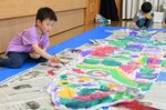 思い思いの色でこいのぼりを彩る子どもたち＝１９日、鳥取市浜坂のアイエム電子鳥取砂丘こどもの国
