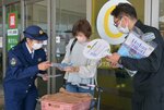 啓発グッズを受け取る買い物客（中央）