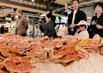 店頭に並んだ松葉ガニを品定めする買い物客＝７日、鳥取市賀露町西３丁目の海産物直売所「かろいち」