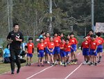 桐生選手（左）に早く走るこつを学ぶ児童ら＝１５日、鳥取市松上の明治小