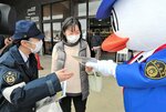 買い物客（中央）にチラシなどを渡し、１１０番通報の適切な利用を呼びかける境港署員ら＝１０日、境港市竹内団地