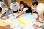 避難所運営ゲームで避難者の受け入れ場所などについて話し合う参加者＝１５日、鳥取市伏野の県立福祉人材研修センター