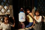　バングラデシュ南東部コックスバザールの難民キャンプで、ＵＳＡＩＤのロゴ入り容器を持つミャンマーのイスラム教徒少数民族ロヒンギャの少女＝３月１６日（ロイター＝共同）