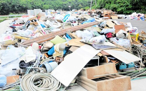 矢田川クリーンセンター跡地の仮置き場に山積みされた災害ごみ＝２３日、香美町香住区油良