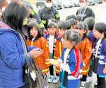 防火を呼びかけ、パンを手渡す園児ら＝１日、鳥取市徳尾の亀井堂