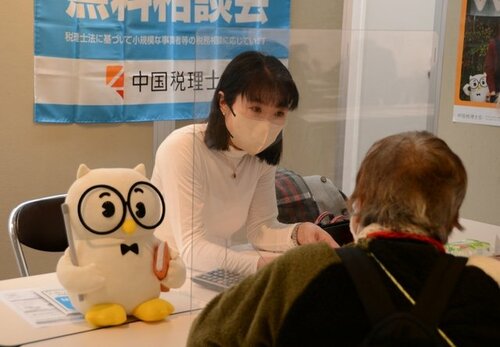 来場者の相談に乗る税理士（左）＝２３日、鳥取市のとりぎん文化会館