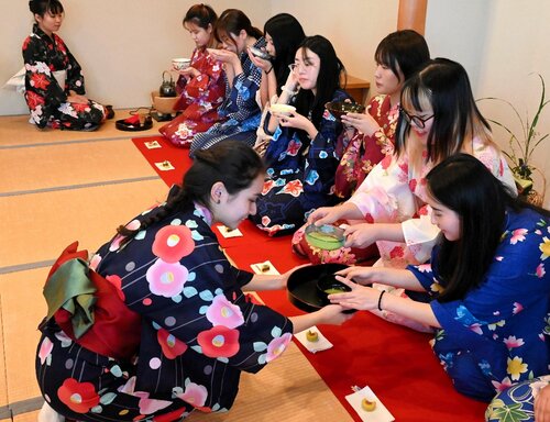 初めての抹茶と和菓子を楽しむ学生ら