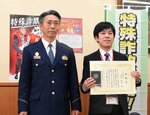 山田署長（左）から感謝状を受け取った井汲さん