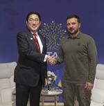 　ウクライナのゼレンスキー大統領（右）と握手する岸田首相＝６月１３日、イタリア南部ファサーノ