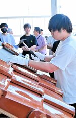 瓦ぶき作業に挑戦する学生